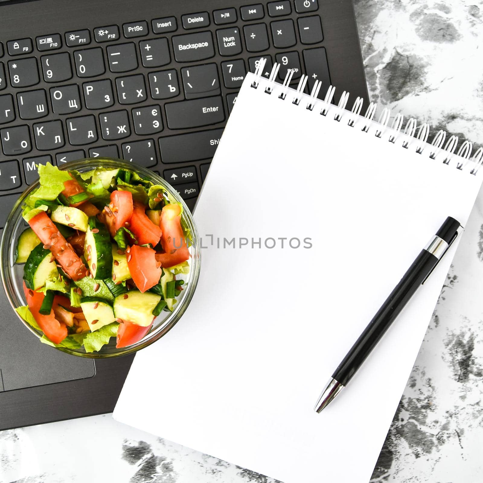 Healthy business lunch snack in office, vegetable salad, empty notebook with pen, copy space, low calorie diet
