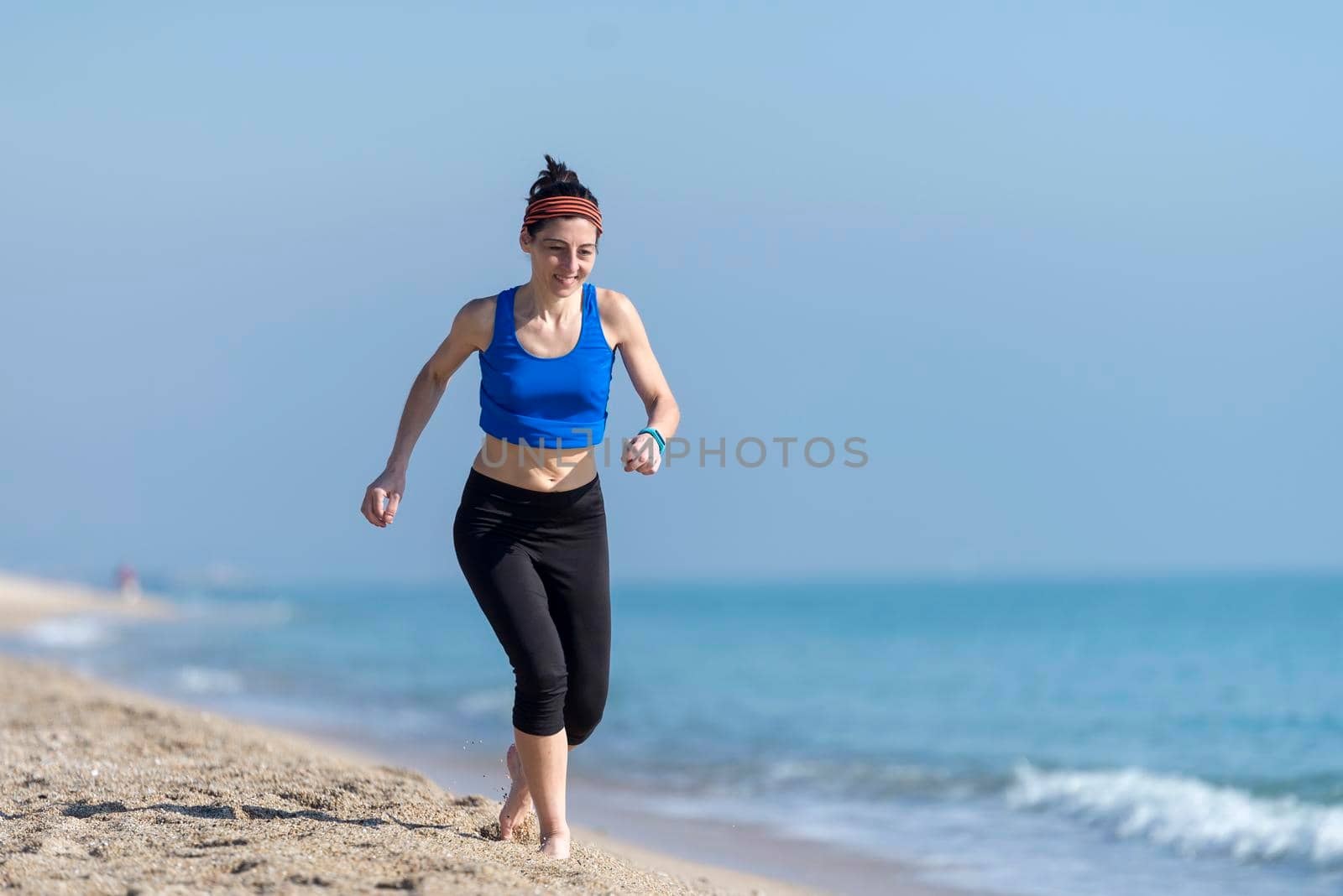 Front view of women jogging on beach close to water by raferto1973