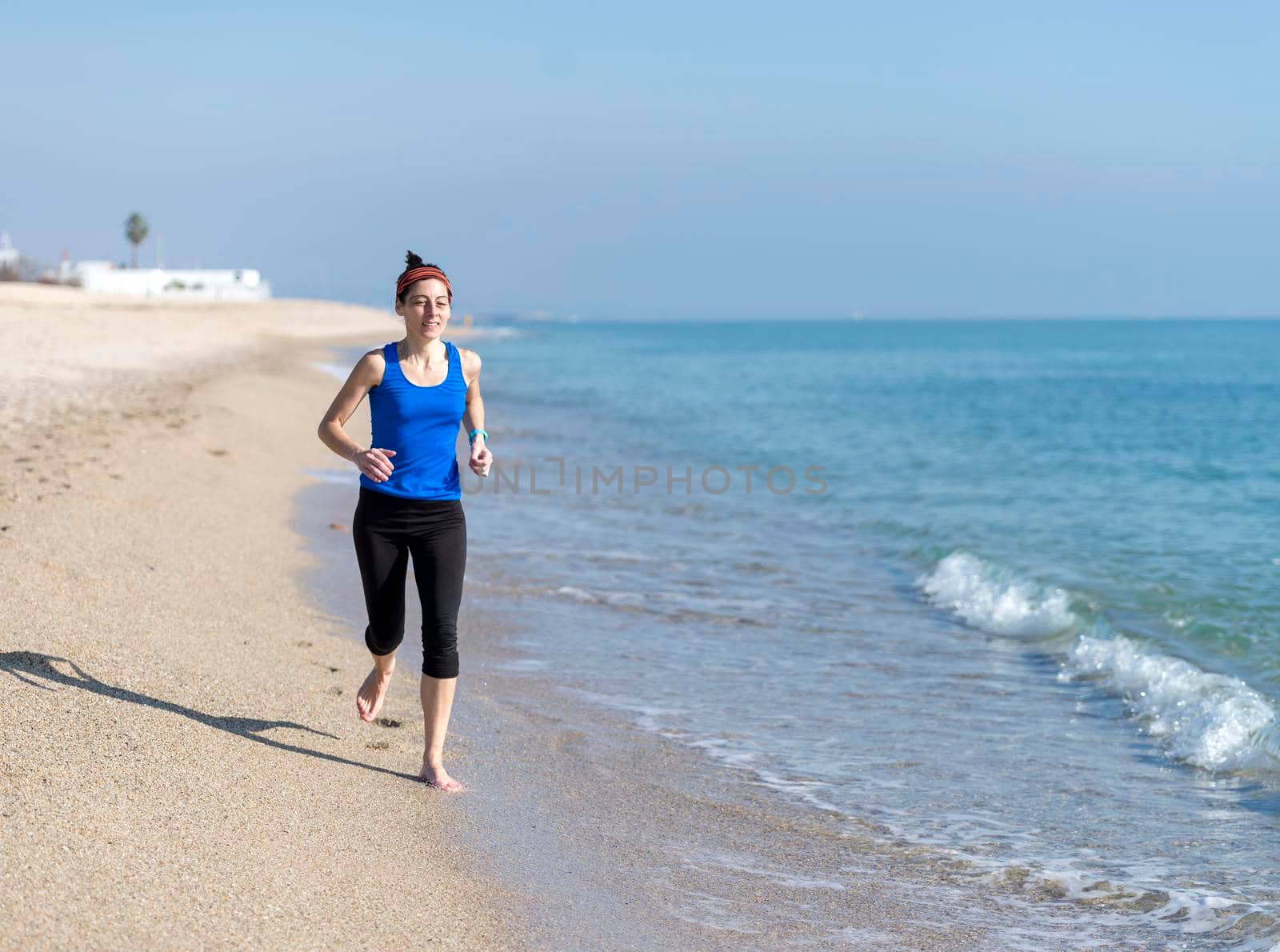 Front view of women jogging on beach close to water by raferto1973