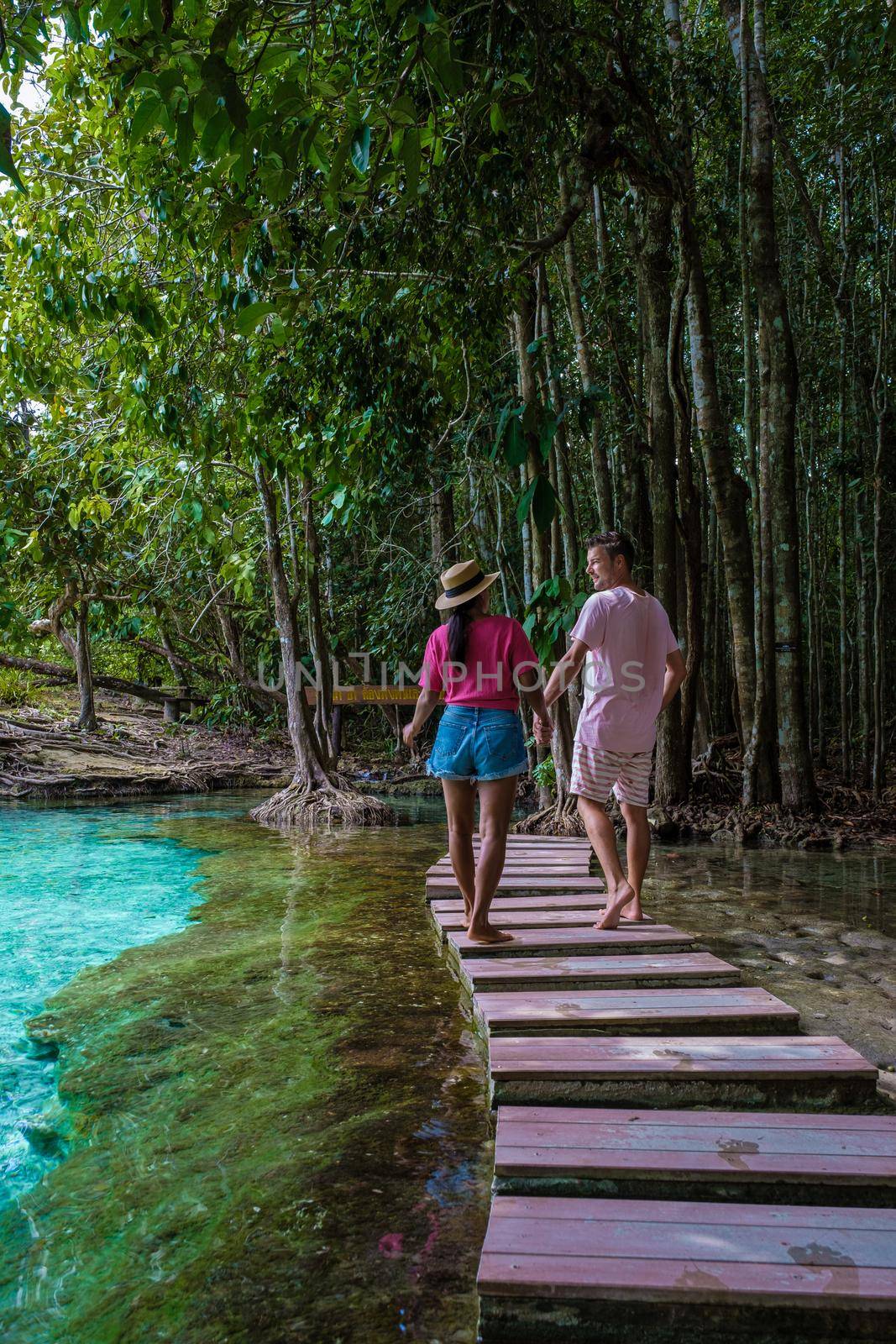 Emerald lake and Blue pool Krabi Thailand mangrove forest Krabi Thailand. Young Asian woman and European men at the lake by fokkebok