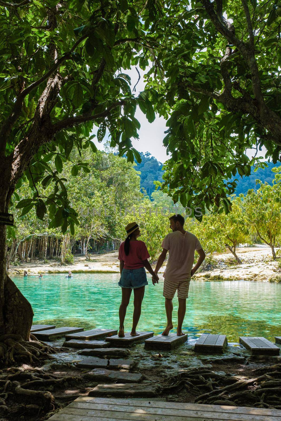 Emerald lake Blue pool Krabi Thailand mangrove forest Krabi Thailand. Young Asian woman and European men at the lake