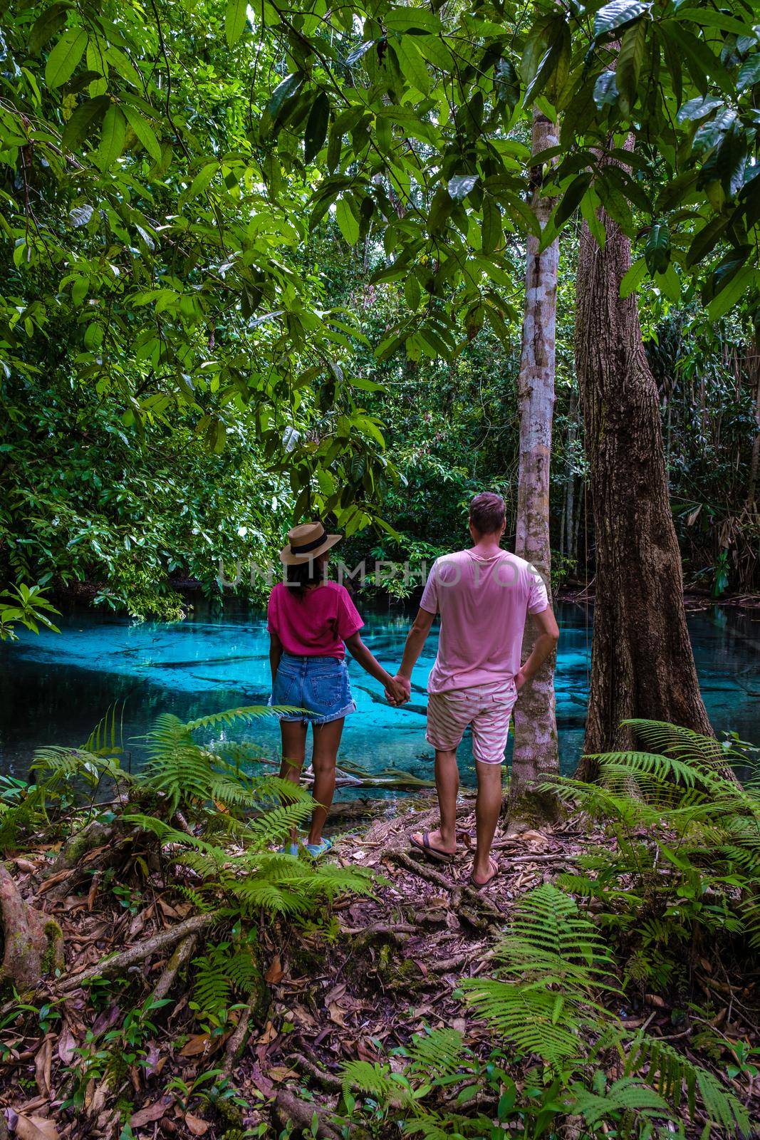 Emerald lake and Blue pool Krabi Thailand mangrove forest Krabi Thailand. Young Asian woman and European men at the lake by fokkebok