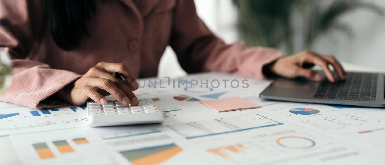 Close up hand of woman using computer calculating household finances or taxes on machine, female manage home family expenditures, using calculator, make payment on laptop.