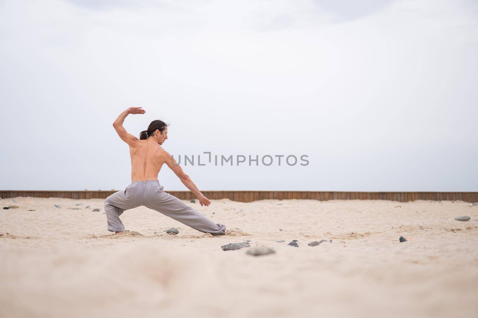 Caucasian man with long hair practicing qigong outdoors