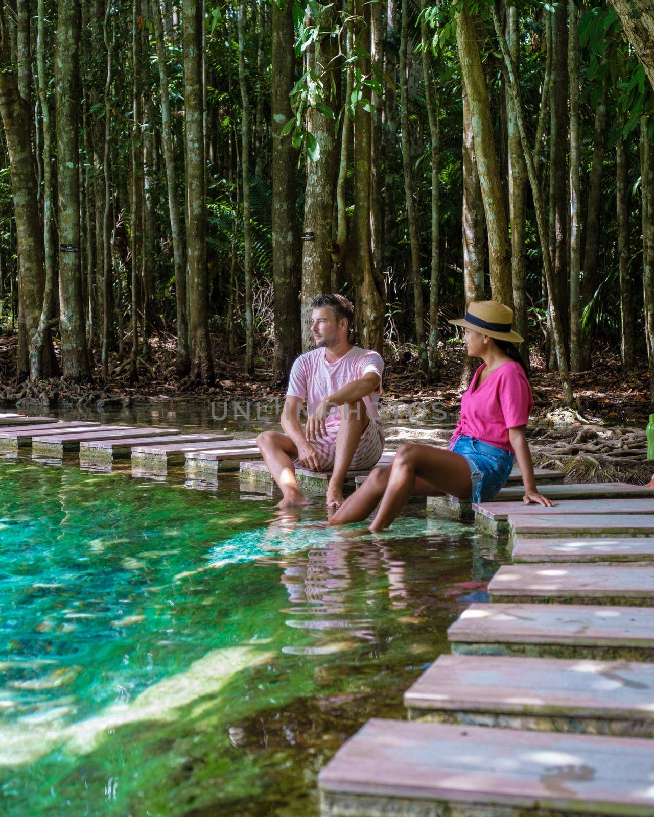 Emerald lake Blue pool Krabi Thailand mangrove forest Krabi Thailand. Young Asian woman and European men at the lake