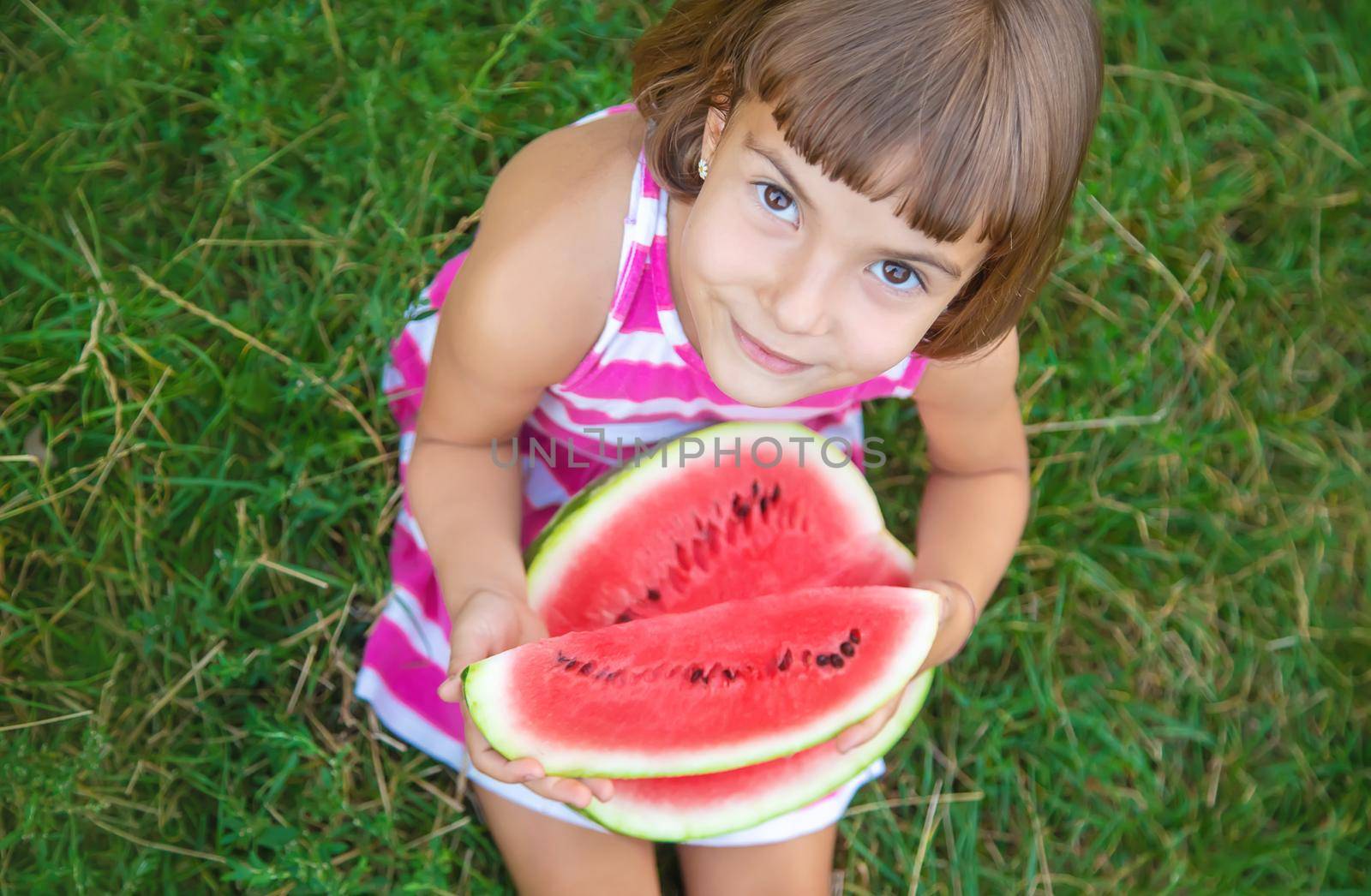 child eats a watermelon in the garden. Selective focus.