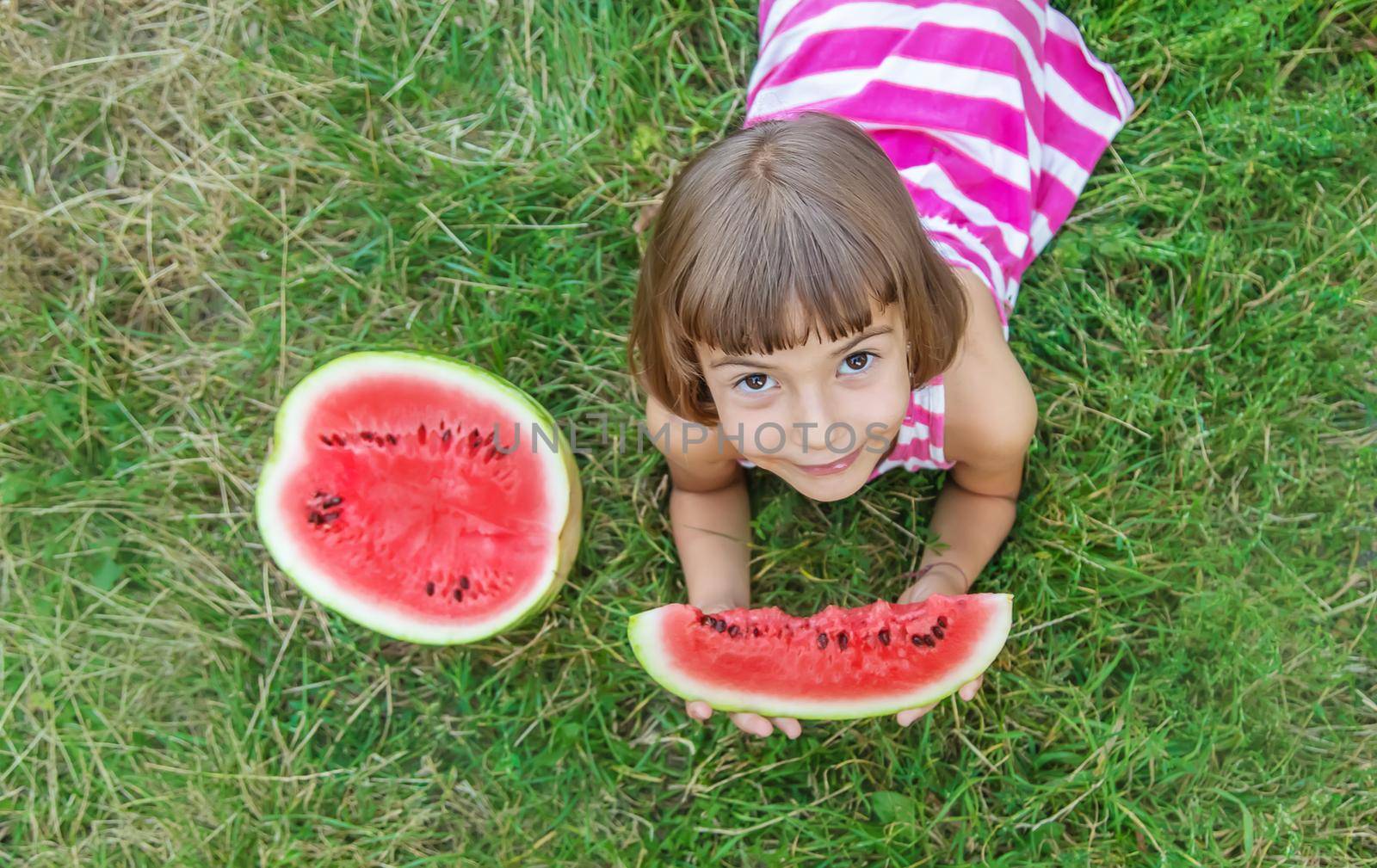 child eats a watermelon in the garden. Selective focus.