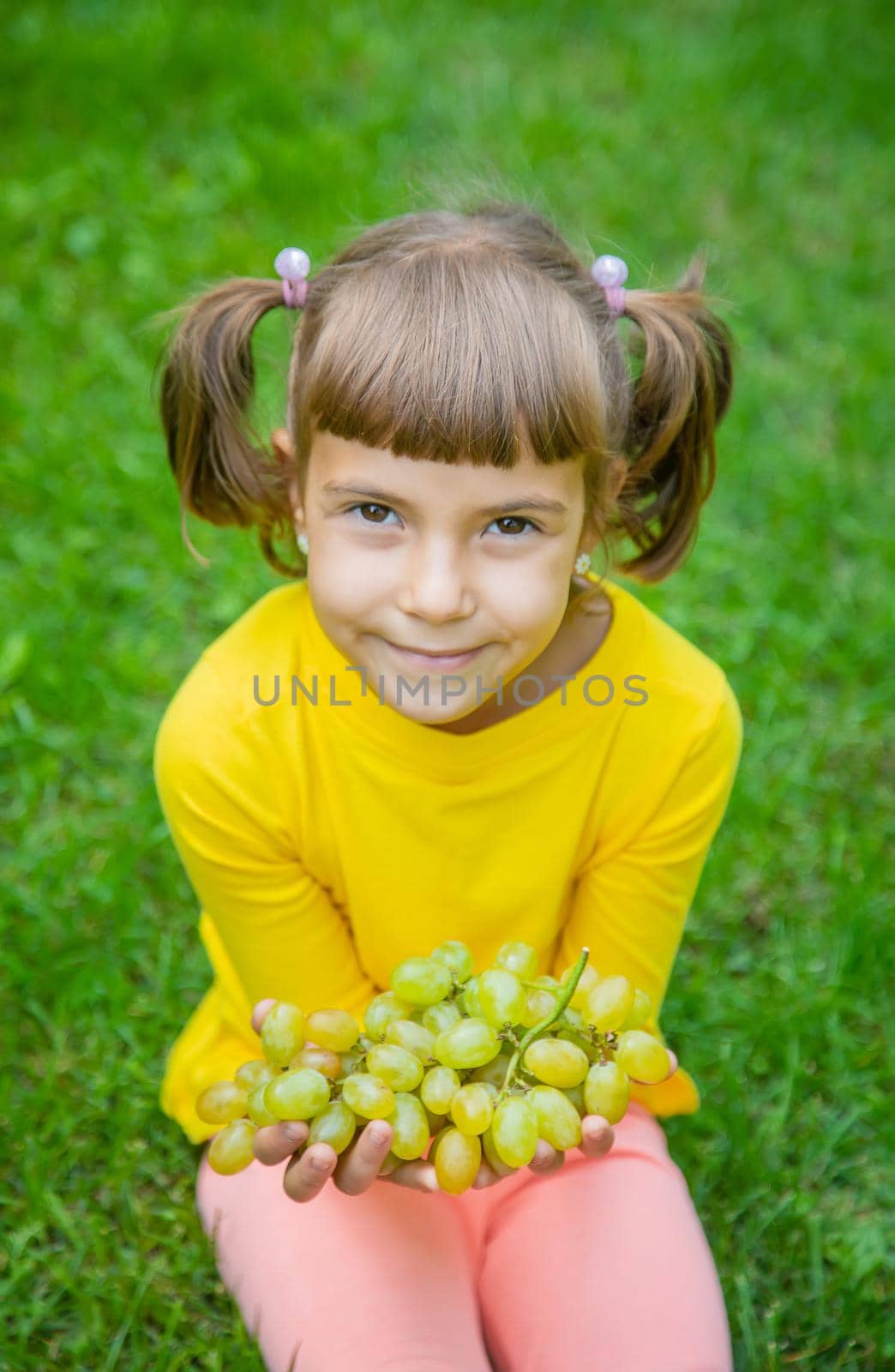 The child eats white grapes. Selective focus. by yanadjana