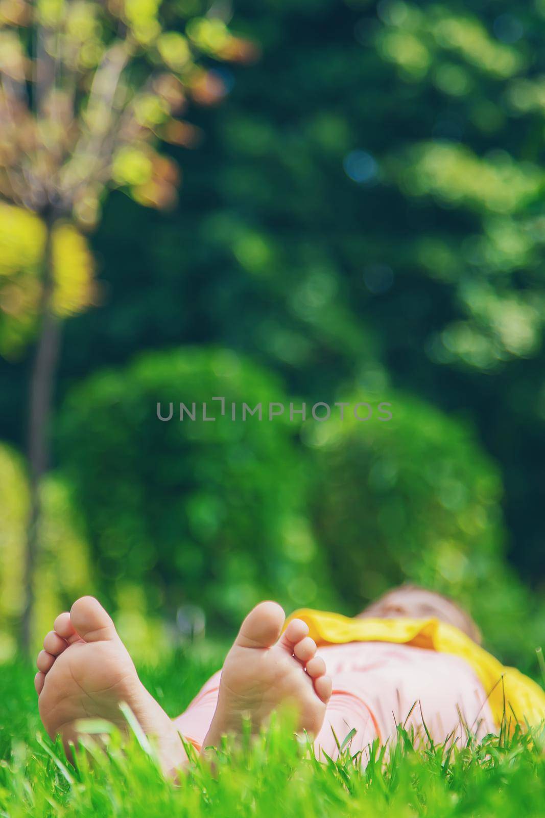 The child lies on the grass. Selective focus. by yanadjana