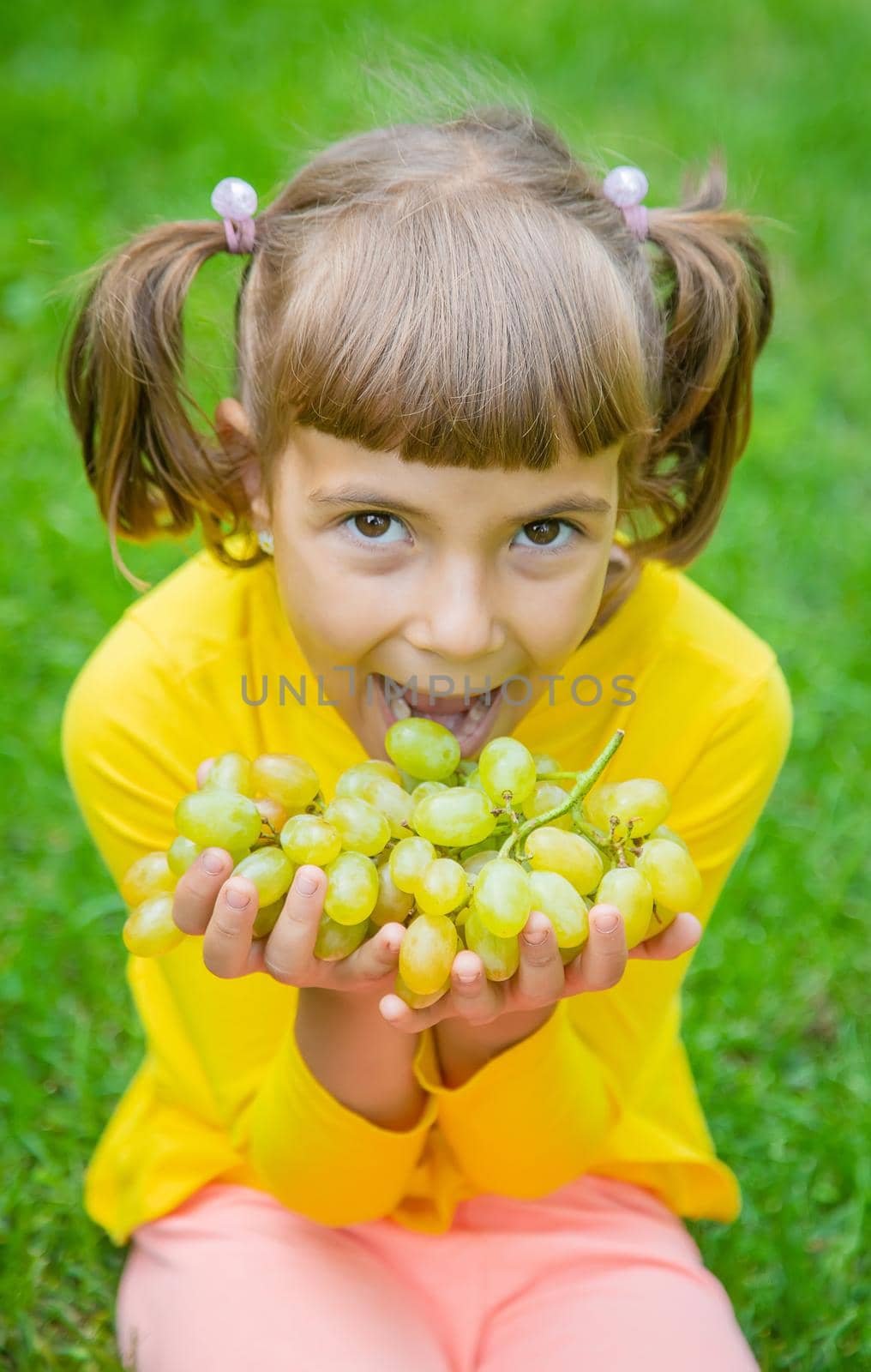 The child eats white grapes. Selective focus. by yanadjana