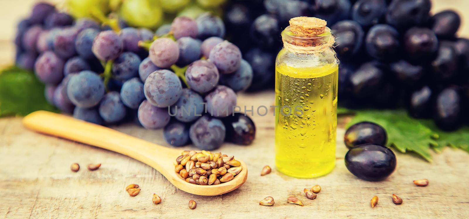 Grape seed oil in a small bottle. Selective focus. by yanadjana