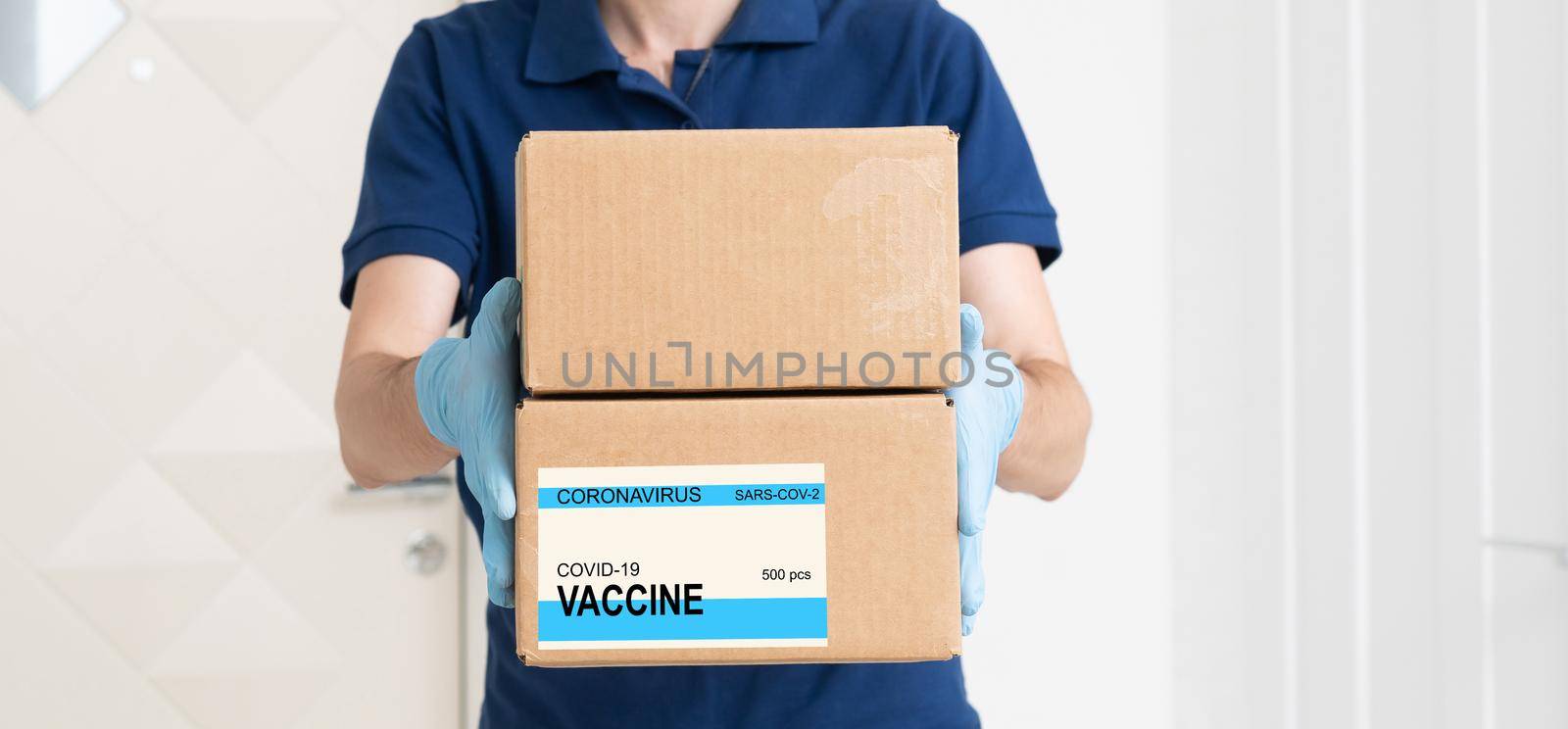 the man delivers the vaccine. Placing VACCINE label on the cardboard box.