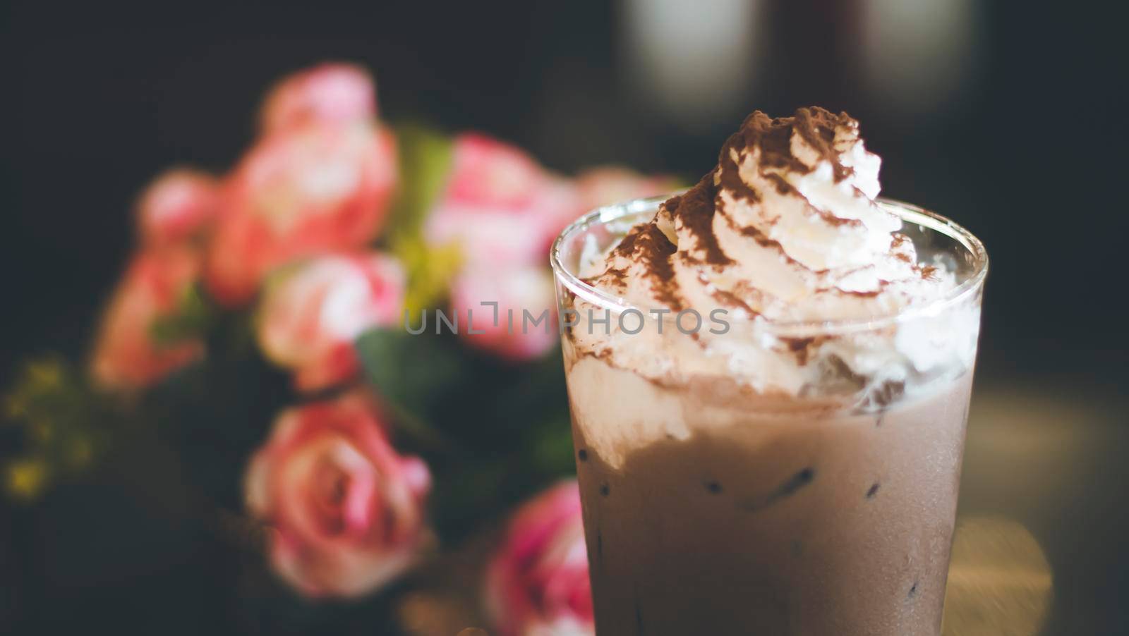 Chocolate frappe with whipped cream, syrup and cookies. Vintage shop background