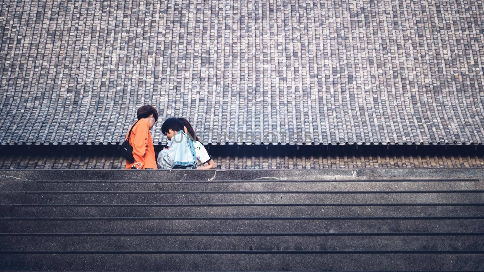 Tourists in front of huge traditional Chinese architecture roof background