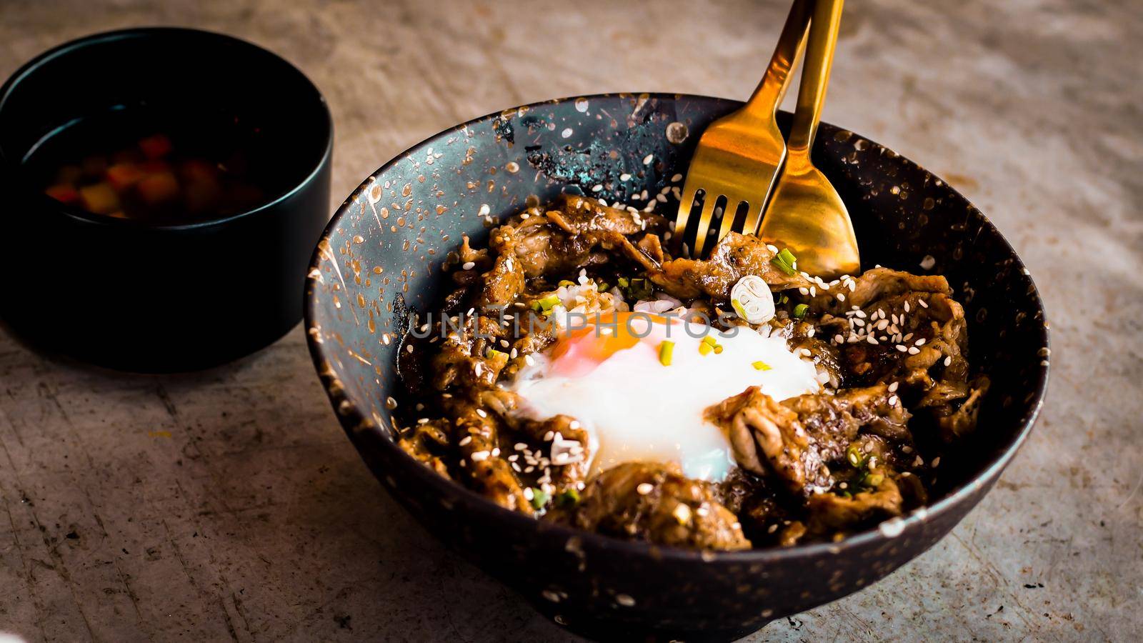 Chicken with rice, onions and broccoli on the table. Horizontal view from above. Japanese food rice serves with chicken in Teriyaki sauce and egg