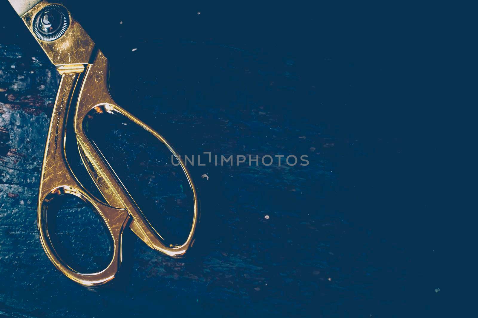 Close-up vintage gold scissor, tailor on dark background. Fashion and sewing concept idea