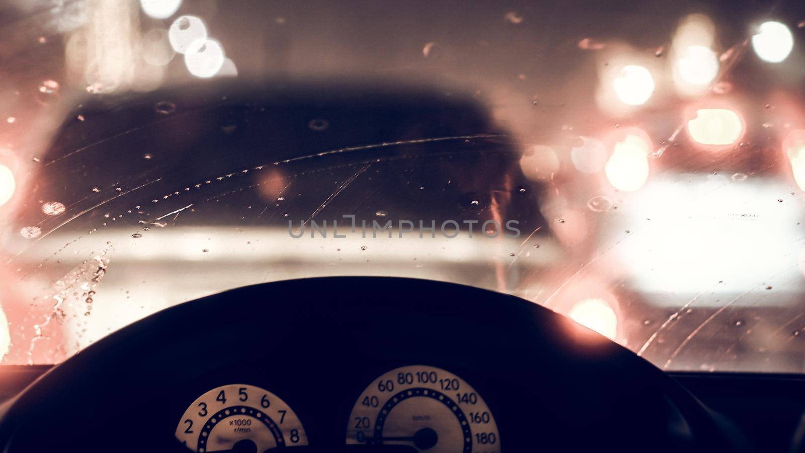 Interior of car when rains. Defocused blur of light on the road in a raining day