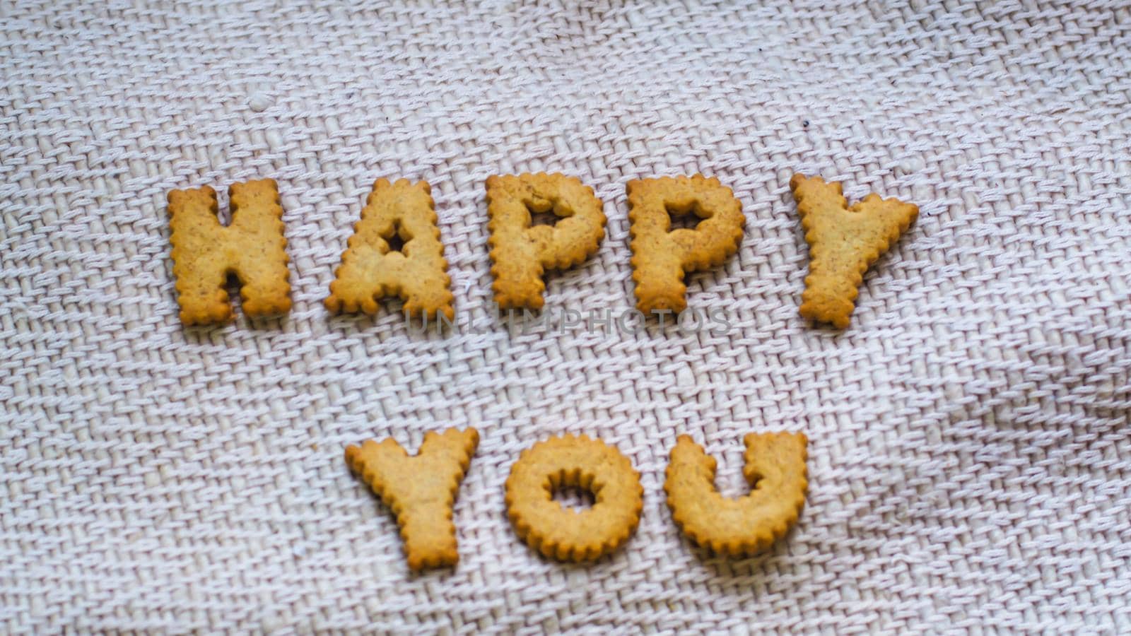 Cookies in the form of the alphabet prospect. Happy from homemade cookies on dark white background. Happy cookies concept