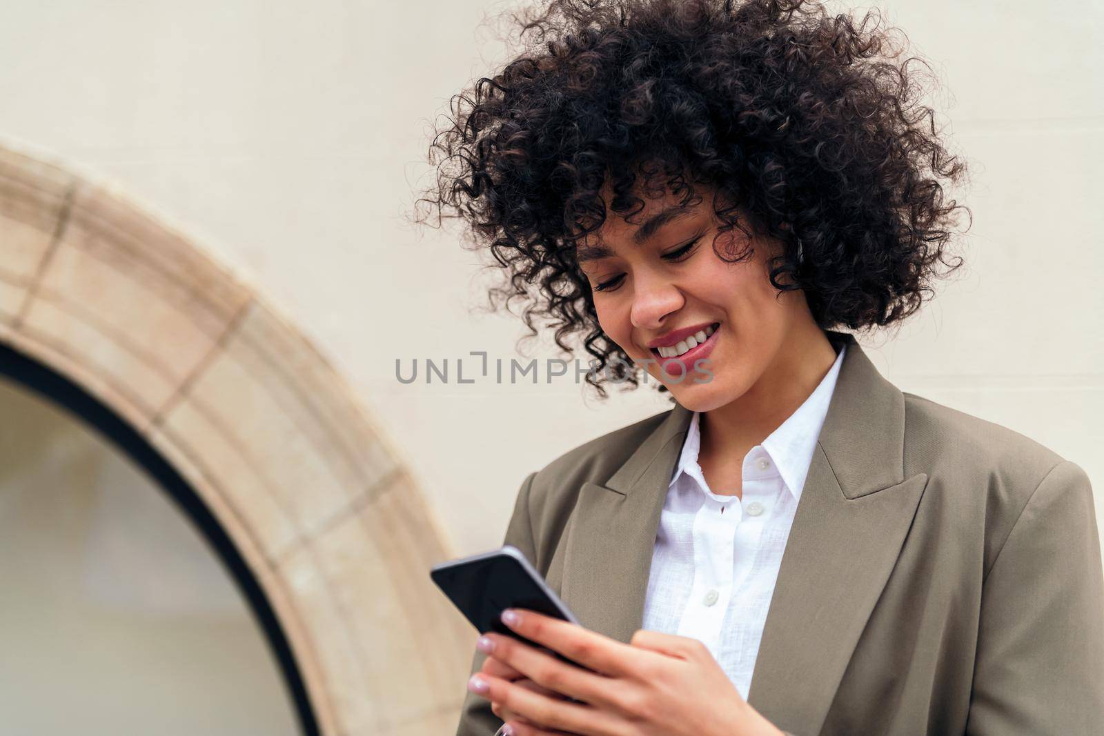 woman smiles happy typing message with her phone by raulmelldo