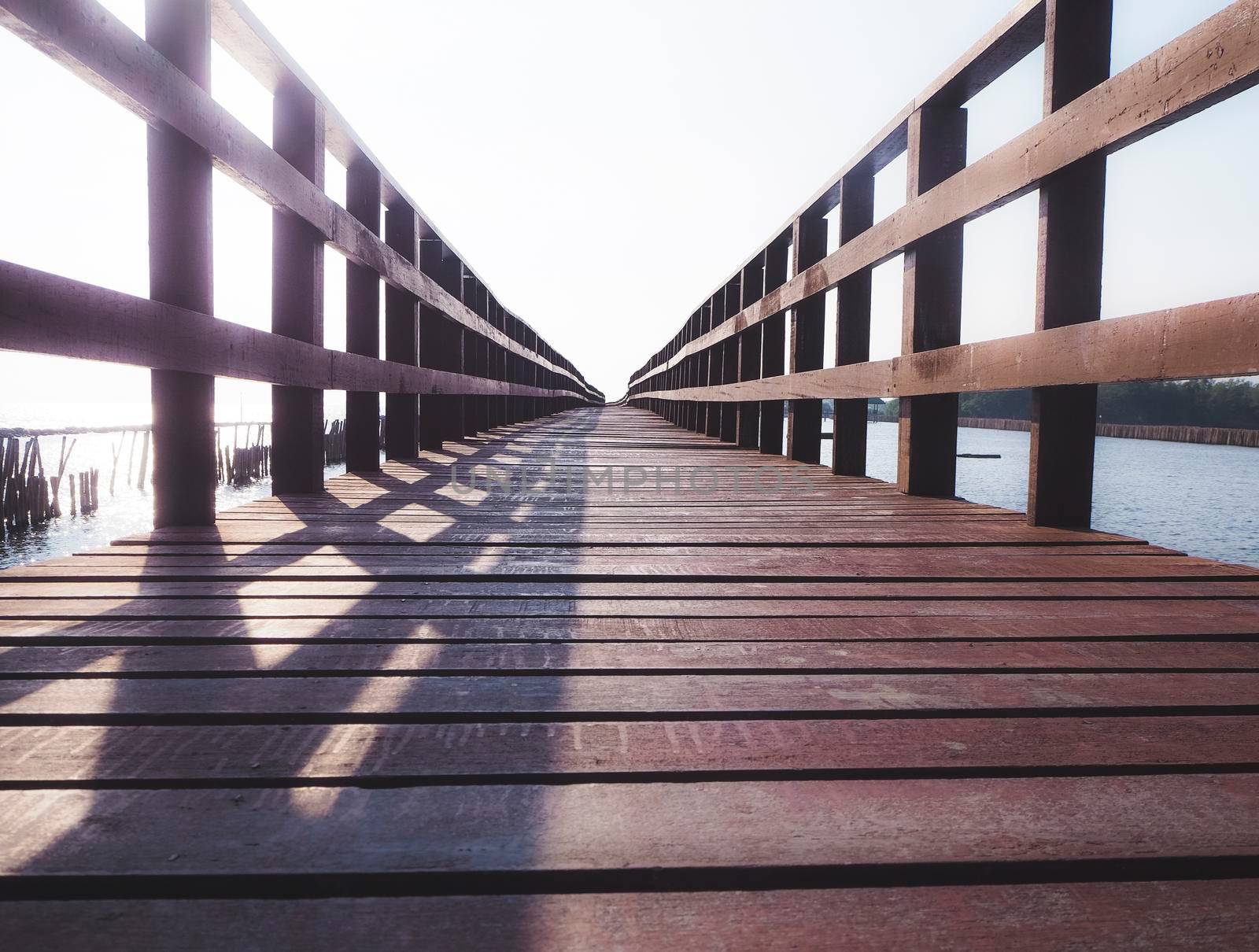 Old Wooden Foot Bridge with handrails over the sea .moving on concept idea