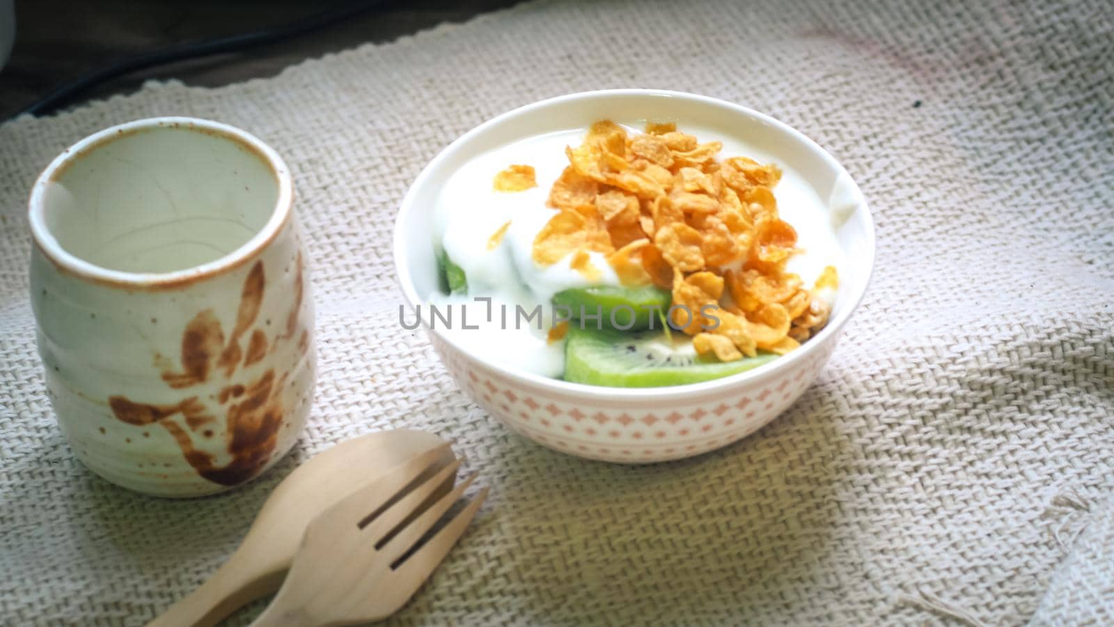 Corn flakes, cereal and milk splash in bowl . Natural homemade plain organic yogurt in wood bowl on wood texture background by Petrichor