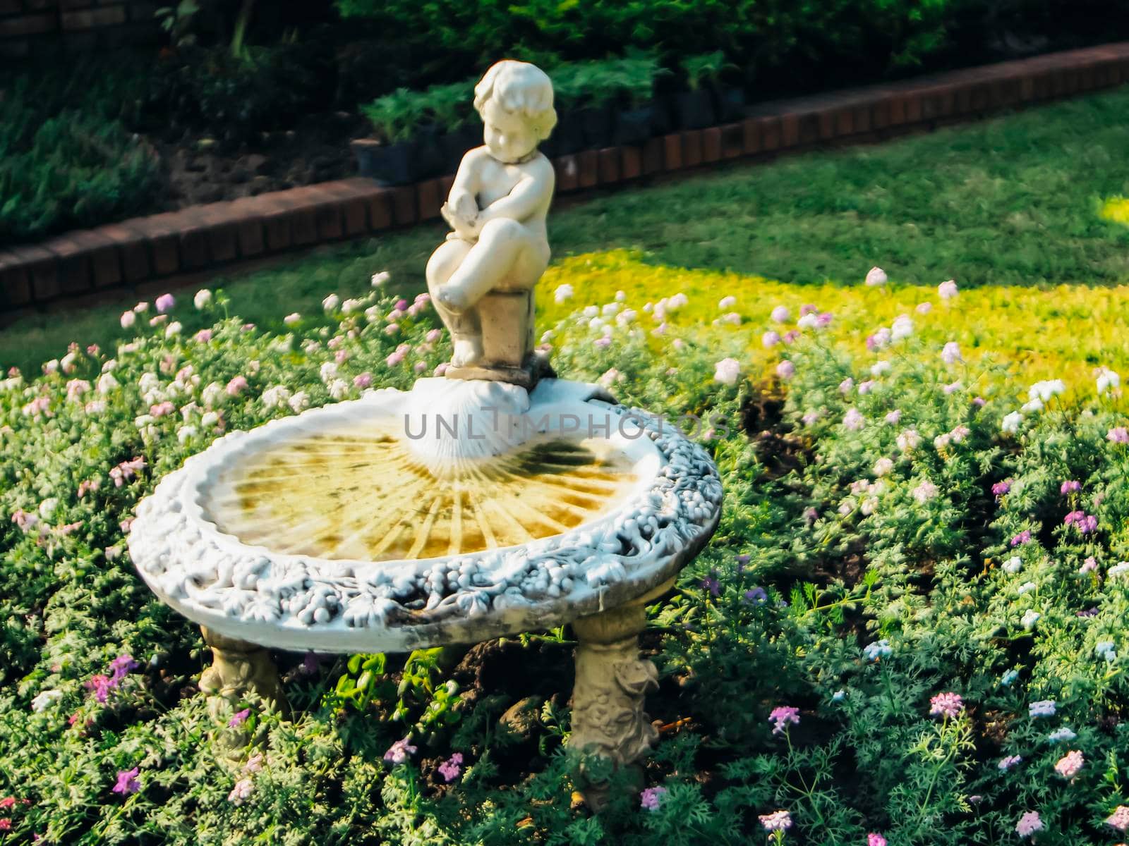 A vintage fountain in the green park which creates aesthetic atmosphere