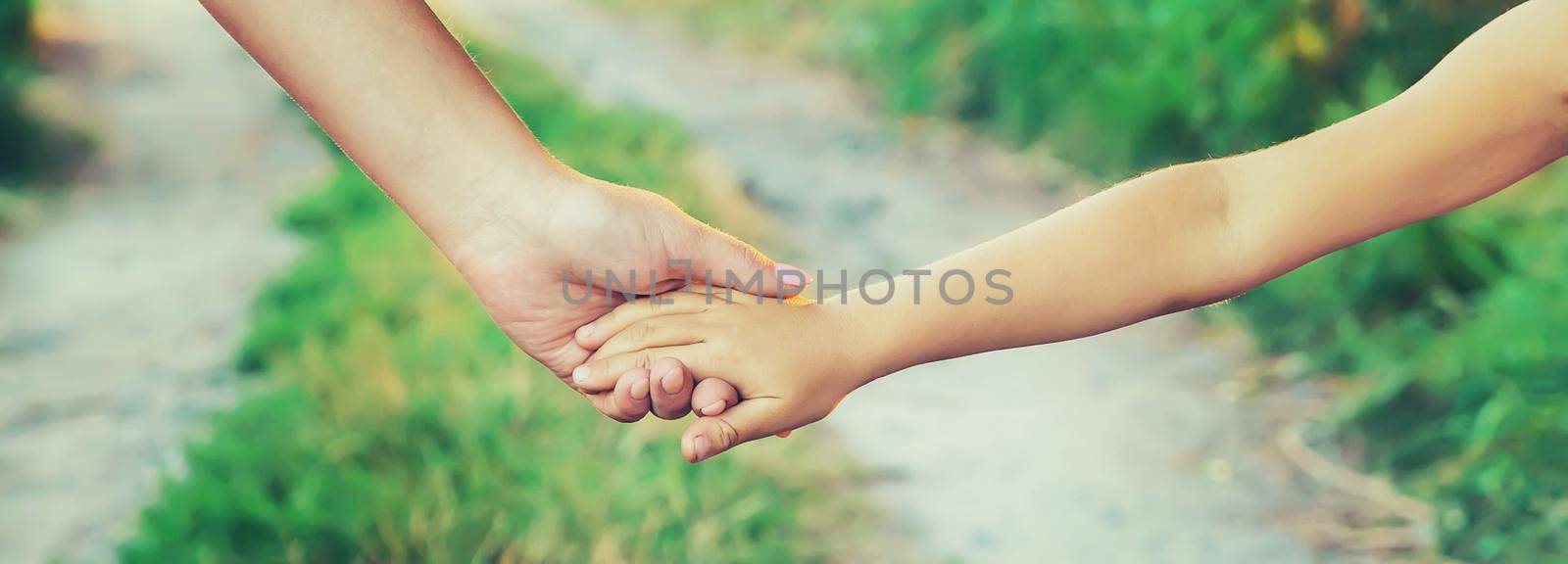 mother and child go by the hand. Selective focus. nature.