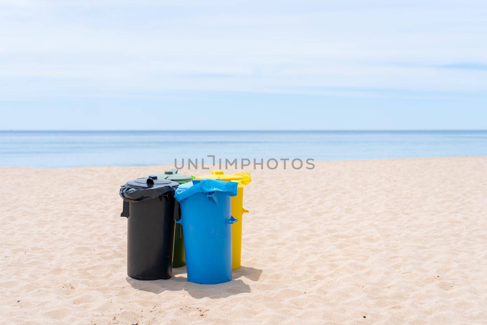 Clean beach garbage bins. Multi colored garbage containers for separate collection of garbage stand on empty beaches near the ocean