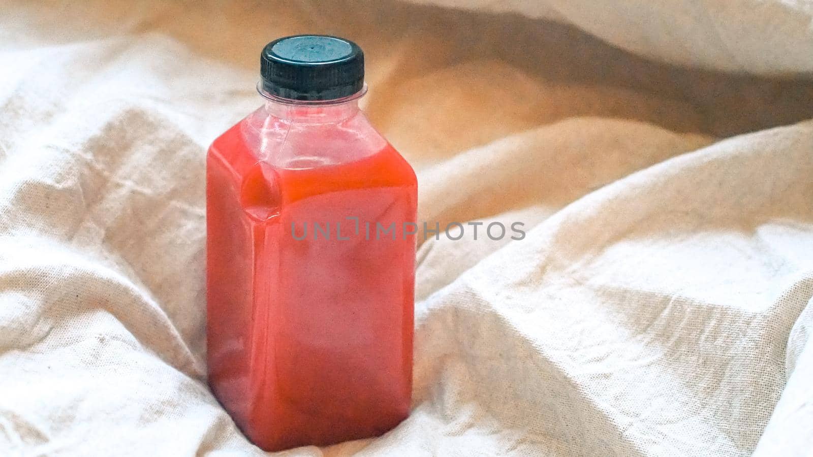 Healthy drink Cranberry juice in a bottle on linen background. Natural concept idea. Health idea.