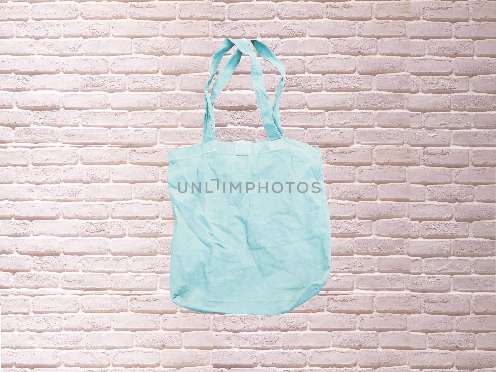 Mock up Tote bag eco hipster white cotton fabric Shopping bag in blue . white brick eall rustic background by Petrichor