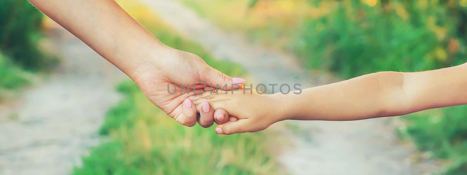 mother and child go by the hand. Selective focus. nature.