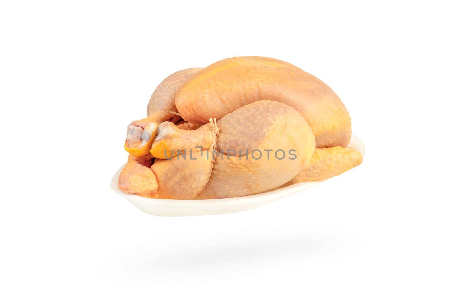 Raw corn chicken isolated on white background. The chicken carcass is packed in a white plastic tray. Yellow meat chicken feed corn.