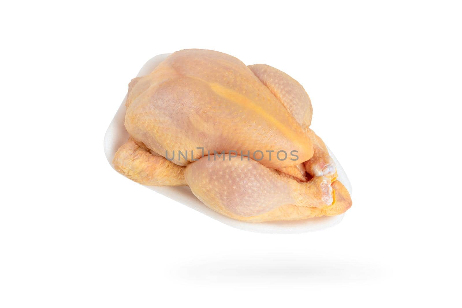Raw corn chicken isolated on white background. The chicken carcass is packed in a white plastic tray. Yellow meat chicken feed corn.