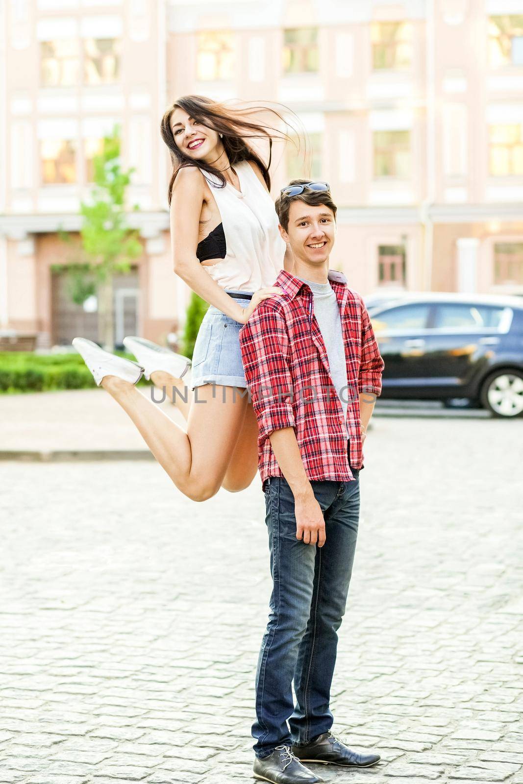 Happy smiling couple having fun in the street on summertime. .