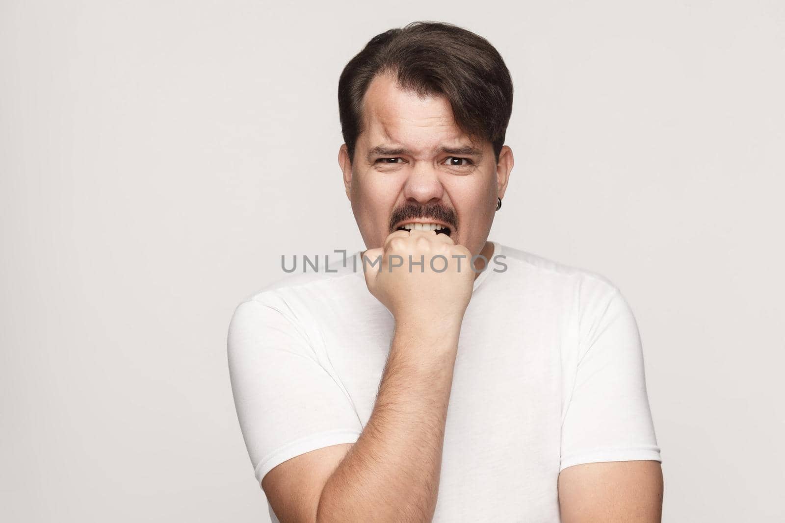 It mistakes! Norvous man looking at camera. Studio shot