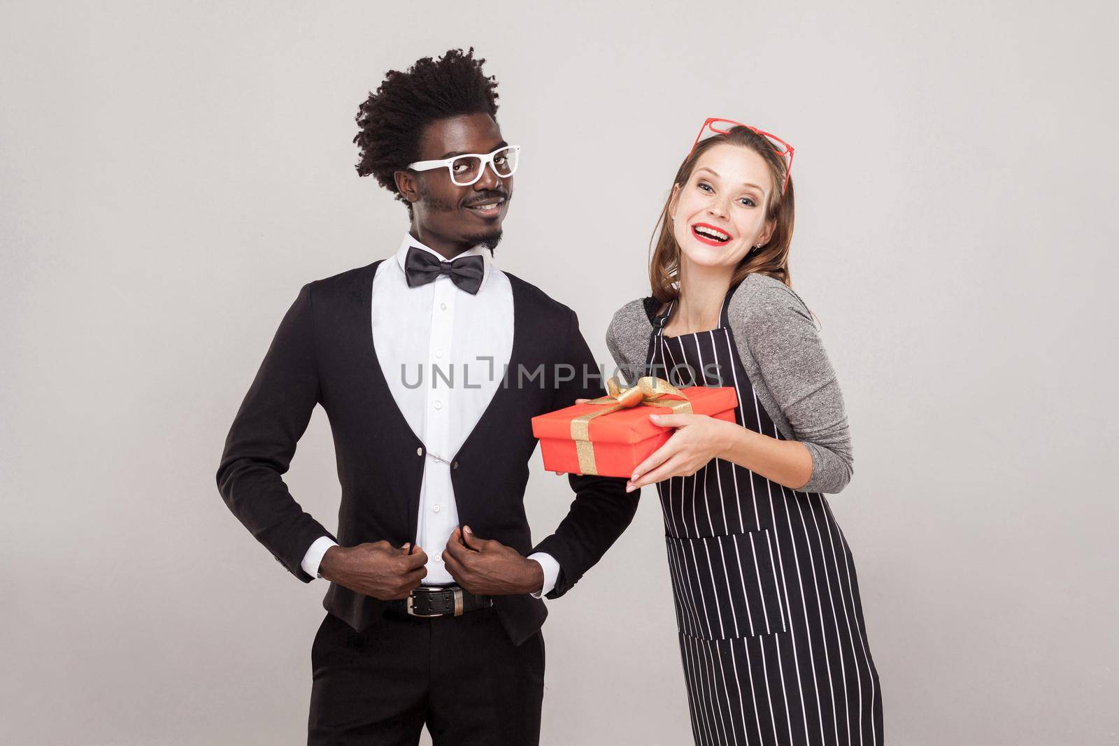 Freckled woman holding gift box, african man standing near by Khosro1