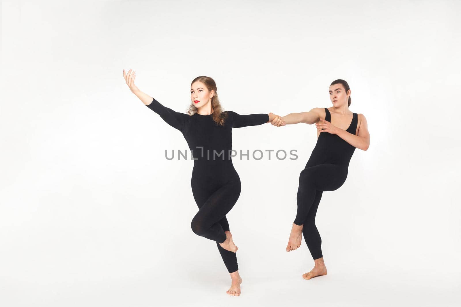 Harmony, partnership. Friends holding hands and dancing. Studio shot, isolated on white background