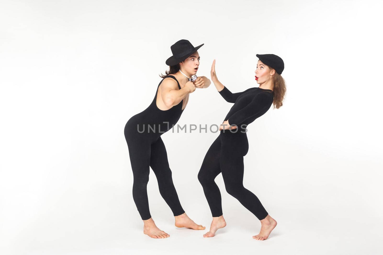 Hey you! Woman showing stop sign young man. Studio shot, isolated on white background