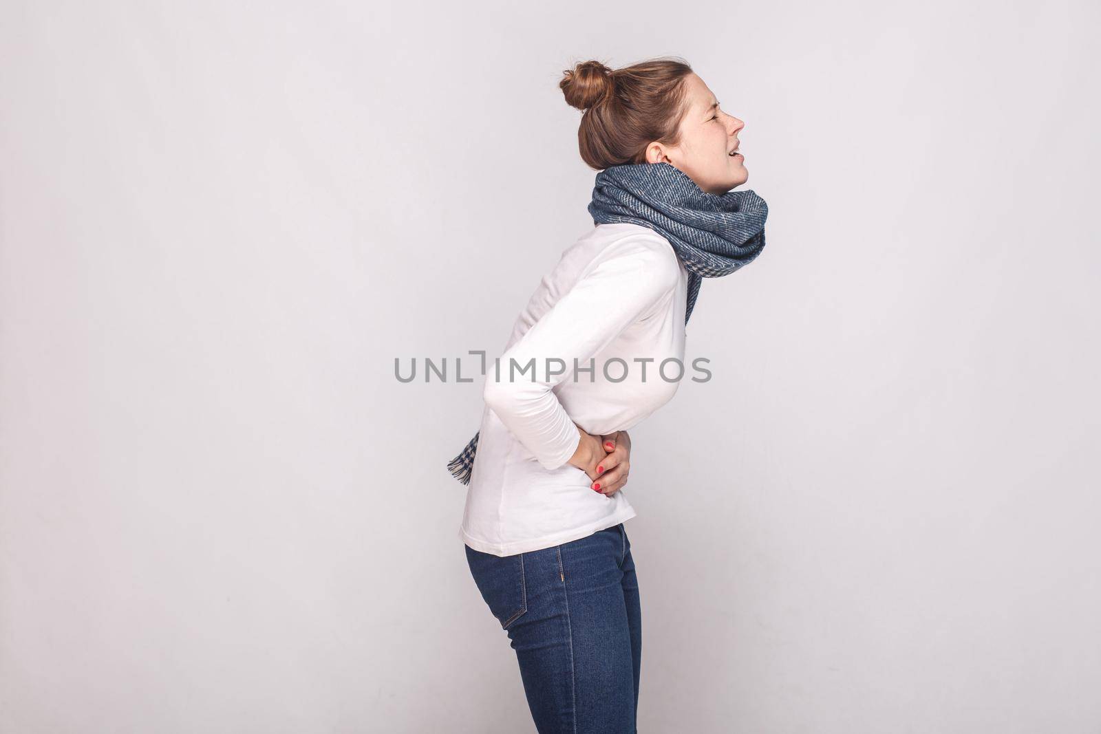 Side view. Periods, monthly, monthlies concept. Young woman have a stomach. Studio shot