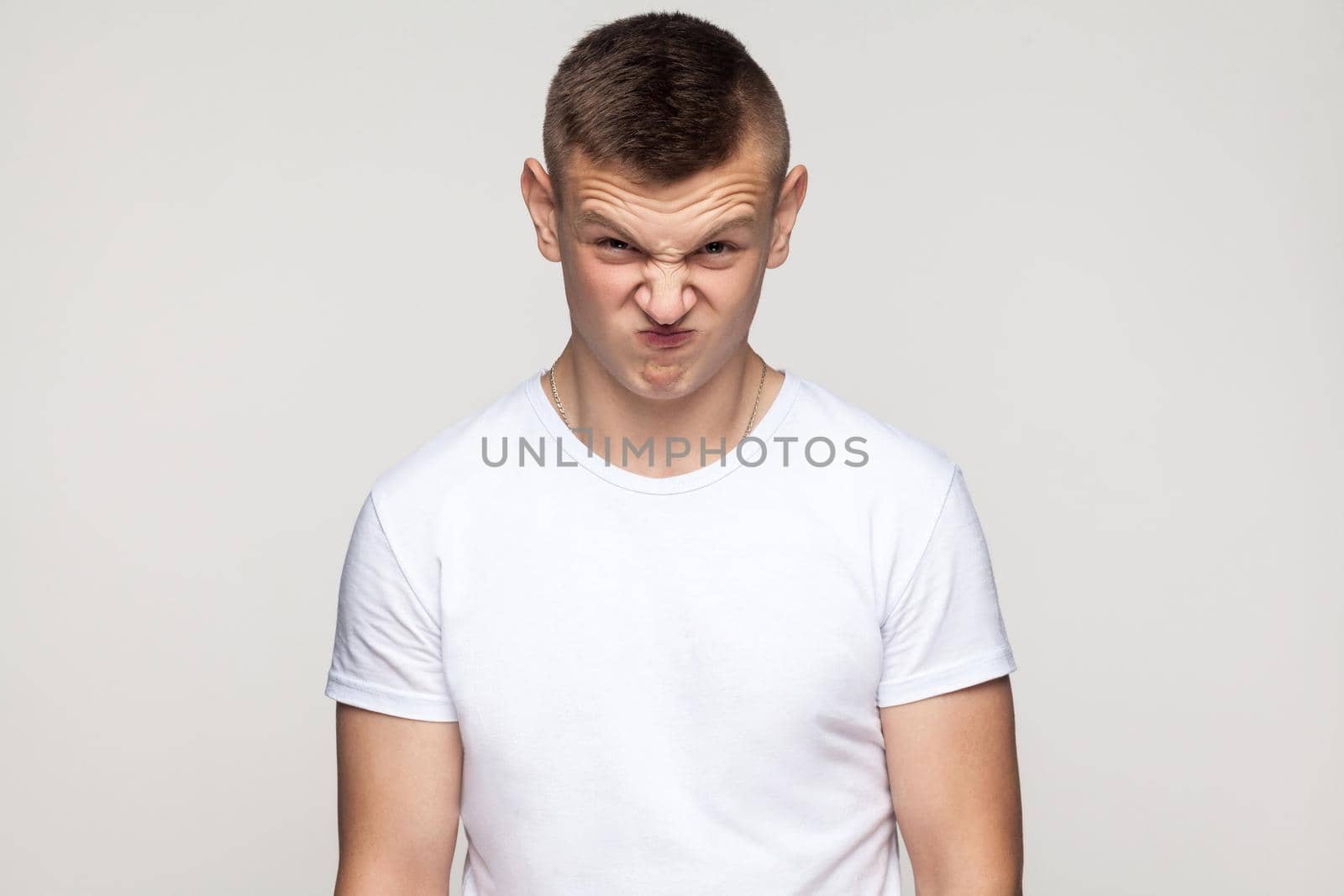 Crazy boy grimacing at camera. Studio shot