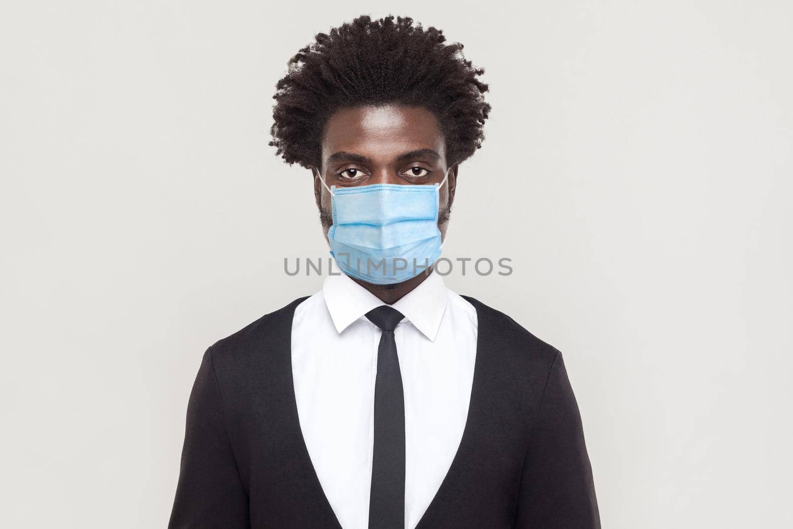 Protection against contagious disease, coronavirus. Man wearing hygienic mask to prevent infection, airborne respiratory illness such as flu, Covid-19. indoor studio shot isolated on gray background