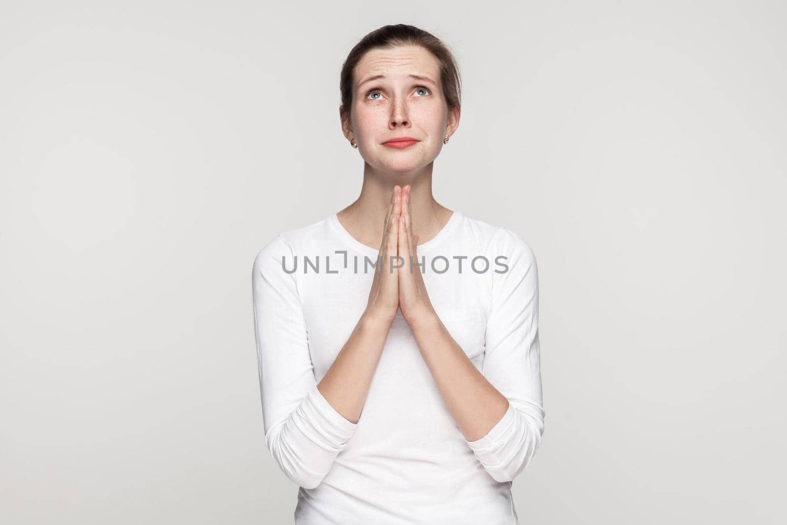 Religion concept. Prayer girl. Studio shot,isolated on gray background