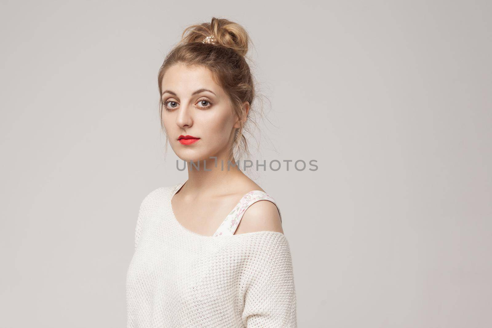 Portrait of cute georgian woman, looking at camera with relax face. Studio shot, gray background
