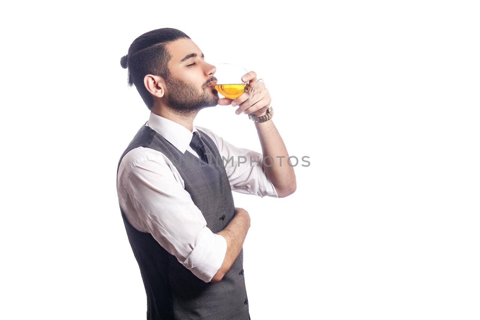 Handsome bearded businessman holding a glass of whiskey. enjoy and drinking with closed eyes. studio shot, isolated on white background.