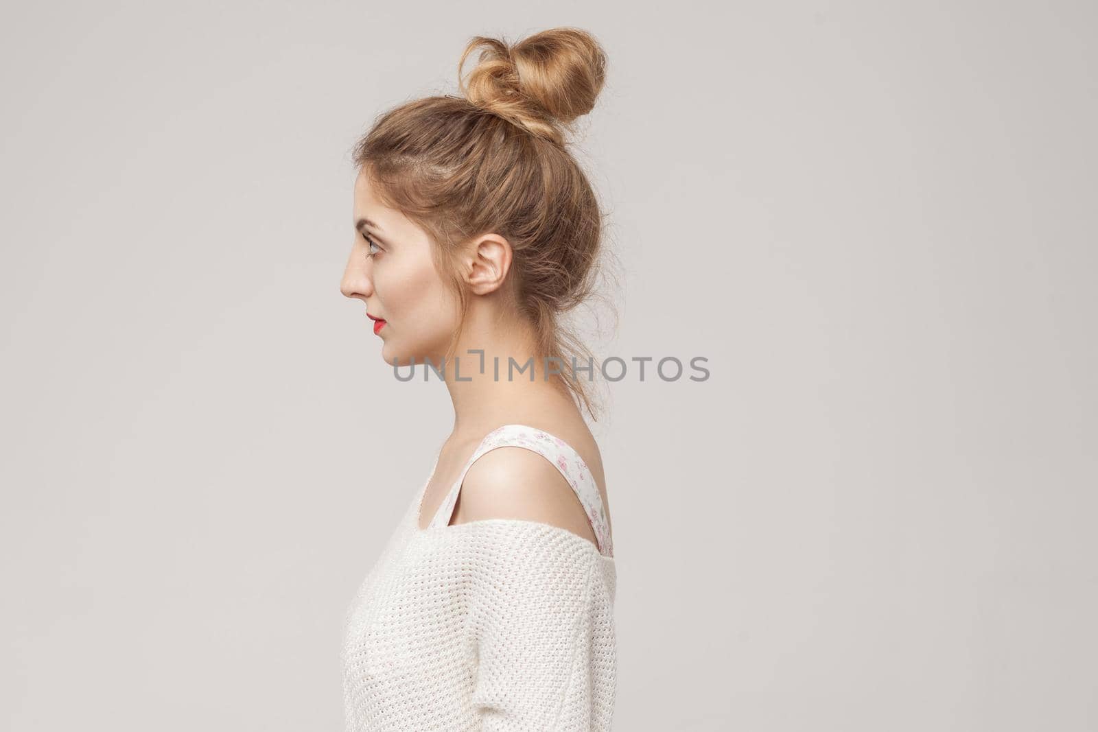 Profile side mixed race blonde woman looking away. Studio shot