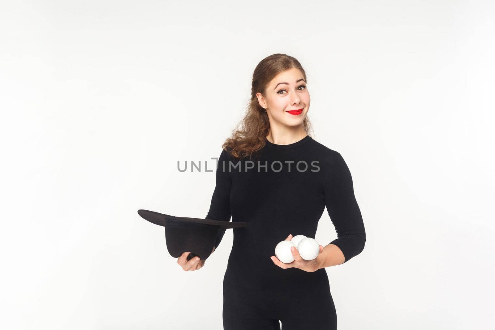 Happiness woman holding juggler balls and hat. Studio shot, isolated on white background
