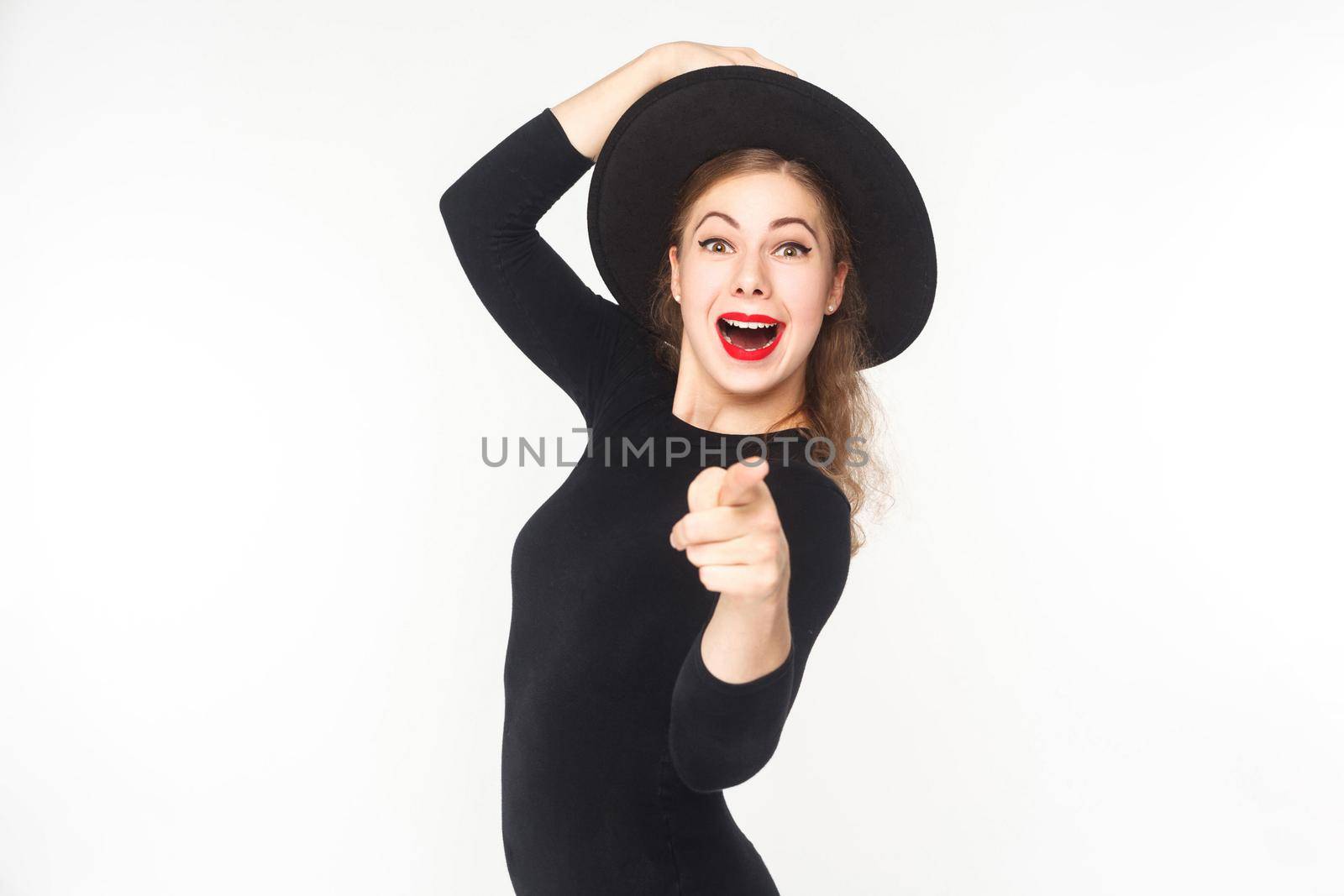 Portrait of cute woman, pointing fingers at camera, open mouth. Studio shot, isolated on white background