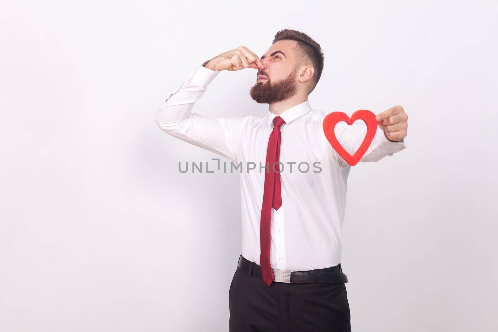 Fuu! Disgustinly, bad smell in love sign. Indoor, studio shot, isolated on gray background