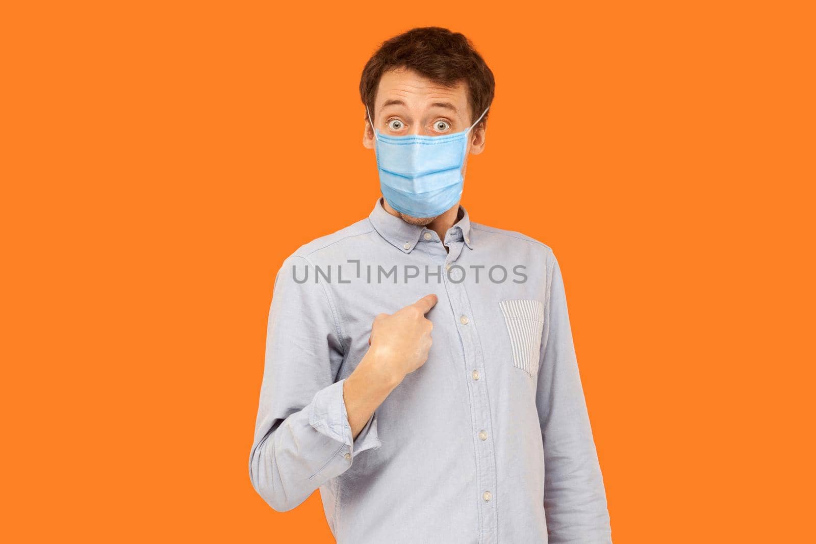man with medical mask standing pointing himself, asking and looking at camera with amazed face. by Khosro1