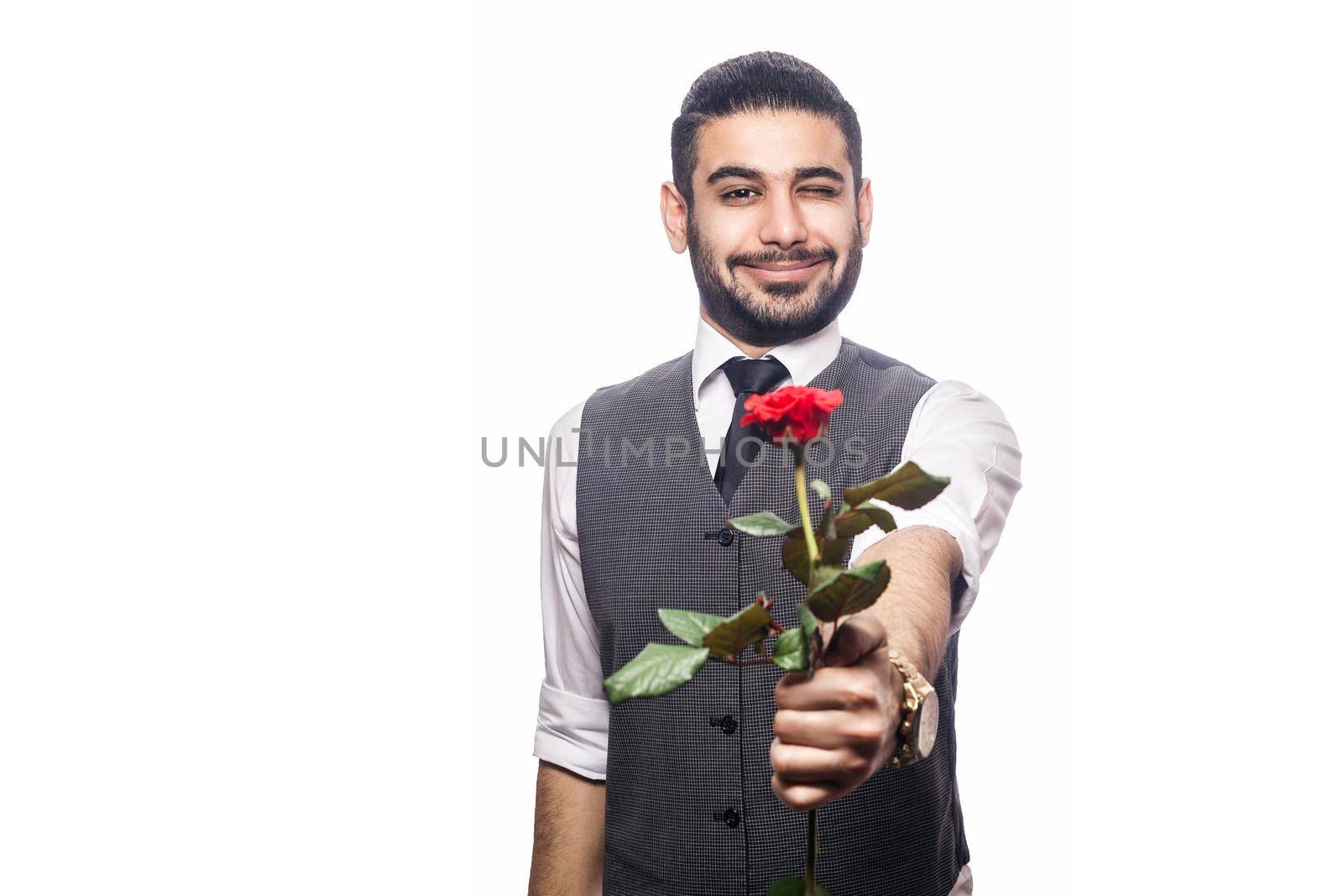 Handsome romantic happy man with rose flower. studio shot. isolated on white background. holding and giving flower and looking at camera and smiling with wink..